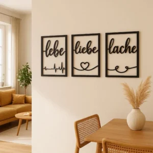 Lebe Liebe Lache - 3 Wandbilder in Schwarz an einer hellen Wand in einem modernen Wohnzimmer